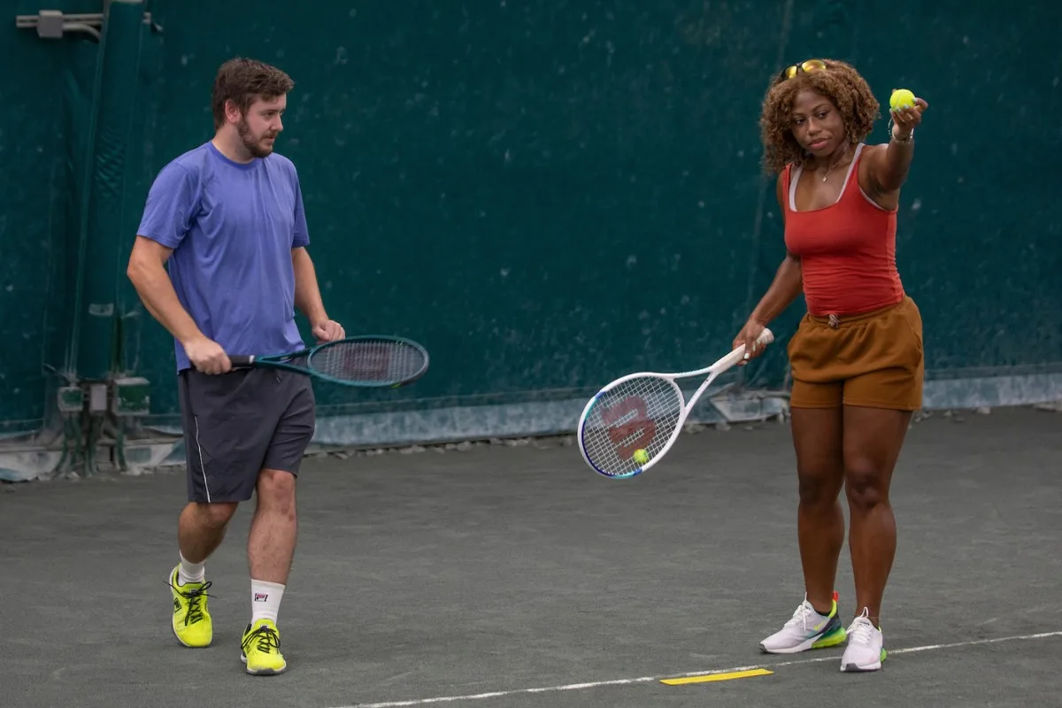 Two adults rallying together in a beginner tennis lesson in Indianapolis